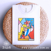 Футболка арт герої білого кольору, зображена зверху на плоскій поверхні, фон світло-сірий. Принт кольоровий, з персонажами, що усміхаються, на фоні плетеного кошика, з яскравими елементами жовтого, червоного та блакитного кольорів.