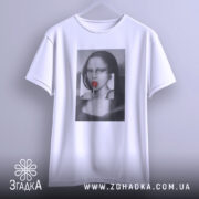 Футболка арт лоліпоп, біла, підвішена на вішалці, фон світло-сірий, принт з жінкою з червоним льодяником, деталі принта чіткі.