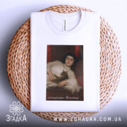 Футболка арт нестримні веселощі, біла, зображена зверху, на кошику з плетеного матеріалу, фон світло-блакитний, принт з зображенням дівчини з котом.