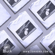 Футболка арт заєць білого кольору, зображена на манекені, ракурс спереду, фон світло-сірий, принт з зображенням зайця в стилі лінійного малюнка на чорному фоні.