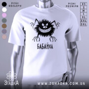 Футболка бабайка білого кольору, зображена з близького ракурсу на манекені, фон світло-сірий, принт чорного кольору з веселим персонажем та написом 'БАБАЙКА'.