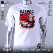 Футболка бабуся пече пиріжки, біла, зображена на манекені, фон світло-сірий, принт з бабусею, що тримає пиріжки, червоний фон за принтом.