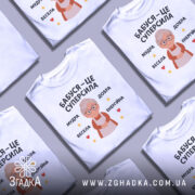 Футболка бабуся це суперсила, біла футболка з принтом, що зображує бабусю з окулярами, на фоні світло-сірого кольору, текст на футболці говорить 'Бабуся – це суперсила', оточений зірочками та сердечками.