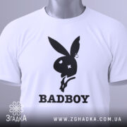 Футболка badboy кролик білого кольору, зображена зверху, на ній видно етикетку з зеленим шнурком, фон світло-сірий, принт чорного кольору з силуетом кролика та написом 'BADBOY'.
