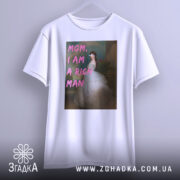 Футболка багата незалежна, білого кольору, зображена на вішалці, фон світло-сірий, принт з написом 'MOM, I AM A RICH MAN' у рожевих літерах на фоні зображення жінки в білій сукні.