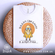 Футболка банан добрі руки, біла, зображена зверху на плетеному кошику, фон світло-сірий, принт з жовтим бананом у окулярах та написом 'Віддам свій банан в добрі руки....'.