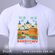 Футболка Бердичів, біла, зображена зверху, фон світло-сірий, принт з архітектурними елементами та квітами, текст 'BERDYCHIV UKRAINE' яскраво-оранжевий, на комірці видна етикетка.