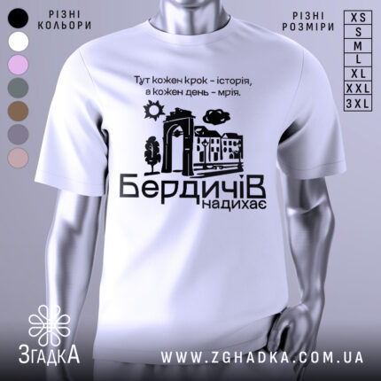 Футболка Бердичів надихає. Біла футболка з коротким рукавом, зображена на манекені, фон нейтральний. Принт містить текст і графічні елементи, що зображують архітектурні деталі та природу.