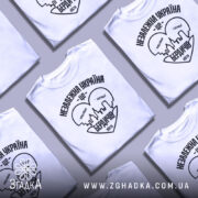 Футболка Бердичів подарунок, біла, зображена на манекені, фон світло-сірий, принт чорного кольору з написом 'Незалежна Україна - це Бердичів' та силуетом міста.