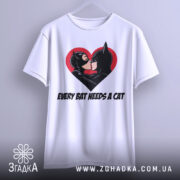 Футболка бетмен кішка кохання, біла, підвішена на вішалці, фон світло-сірий, принт з червоним серцем, на якому поцілуються персонажі Бетмен і Кішка.
