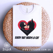 Футболка бетмен кішка кохання, біла, складена на плетеному кошику, фон світло-сірий, принт з червоним серцем, на якому поцілуються персонажі Бетмен і Кішка.