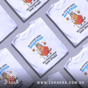 Футболка без подарунків зрада. Білий колір, зображена спереду на манекені, фон світло-сірий. Принт з мультяшним конем у червоному халаті, що тримає палицю, з пташками навколо.