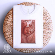 Футболка білка лісова марка, біла, зображена на плетеній кошику, фон світлий, принт з білкою на дереві в червонувато-коричневих тонах.