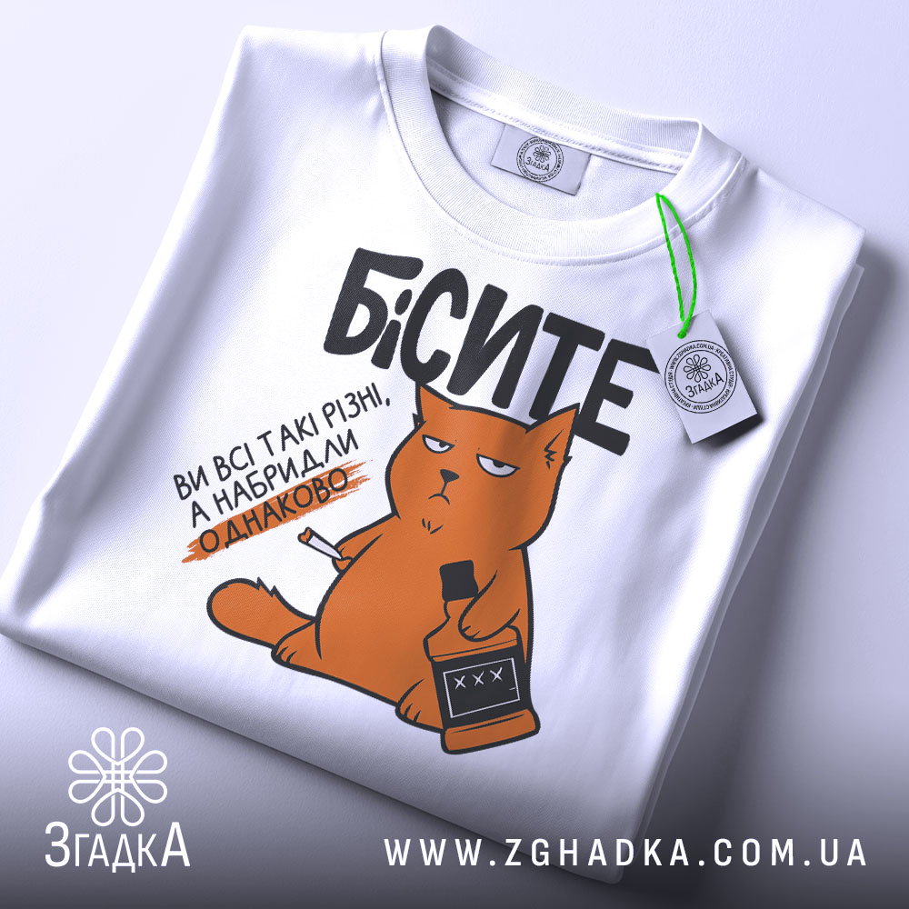 Футболка бісите всі однаково, біла, зображена зверху, фон світлий, принт з оранжевим котом, що тримає пляшку і сигарету, текст чорний, на комірці є етикетка.