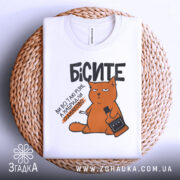 Футболка бісите всі однаково, біла, зображена на плетеній основі, фон нейтральний, принт з оранжевим котом, що тримає пляшку і сигарету, текст чорний.