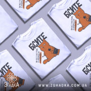 Футболка бісите всі однаково, біла, зображена на манекені, фон нейтральний, принт з оранжевим котом, що тримає пляшку і сигарету, текст чорний.