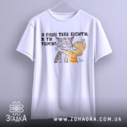 Футболка бісити терпіти, біла, підвішена на вішалці, фон світлий, принт з двома котами, один з котів з жовтими смужками, інший сірий, текст українською: 'Я буду тебе бісити, а ти терпи!'