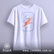 Футболка біжу волосся позаду, біла, підвішена на вішалці, фон світлий, принт з рожевим персонажем, що біжить, з короною та блакитним волоссям, оточений зірочками та лініями.