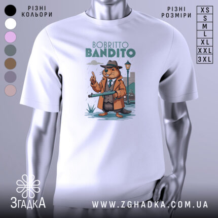 Футболка Bobritto Bandito білого кольору, зображена на манекені з правого боку, фон світло-сірий, принт з ведмедем у капелюсі та пальто, що тримає гвинтівку, на фоні вуличного ліхтаря та будинків.