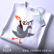 Футболка бойовий гусак, біла, зображена з верхнього ракурсу, на фоні світло-сірого градієнту, принт з гусаком, що тримає пляшку з вогнем, виконаний у сірому, оранжевому та чорному кольорах, з етикеткою зеленого кольору.