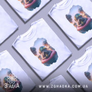 Футболка бойовий тюлень, біла, зображена на манекені, фон світло-сірий, принт з тюленем у військовій касці на рятувальному колі, навколо дим і вибухи.