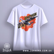 Футболка Bombombini Gusini білого кольору, підвішена на вішалці, з принтом птаха та літаків на червоному фоні, з акцентом на деталі принта.