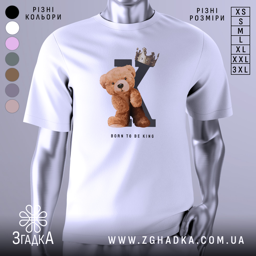 Футболка born king, білого кольору, зображена на манекені з блискучою поверхнею, фон світло-сірий, принт з ведмедиком та короною на літері K, текст 'BORN TO BE KING' під малюнком.