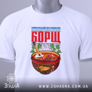 Футболка борщ подарунок, біла, складена на поверхні, фон світлий, принт з червоною написом 'БОРЩ' та малюнком тарілки з борщем, прикріплена етикетка.