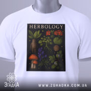 Футболка ботанічний арт, біла, складена на столі, фон світло-сірий, принт з рослинами та грибами, тег з логотипом прикріплений до коміра.