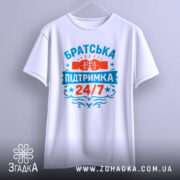 Футболка братська підтримка, біла, зображена спереду на вішалці, фон світло-сірий, принт яскравий з червоними та блакитними кольорами, напис 'Братська підтримка 24/7' та зображення кулаків.