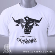 Футболка брутальна скотиняка, білого кольору, зображена зверху, на плоскій поверхні, фон світлий, принт чорного кольору з графічним зображенням голови корови та написом 'Брутальна скотиняка', з зеленим ярликом.