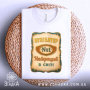 Футболка бухгалтер номер один, біла, зображена зверху на плетеній основі, фон світлий, принт з написом 'БУХГАЛТЕР No1 Найкращий в світі' з декоративними елементами.