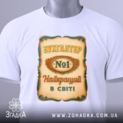 Футболка бухгалтер номер один, біла, зображена зверху, фон світлий, принт з написом 'БУХГАЛТЕР No1 Найкращий в світі' з елементами декору, на футболці є етикетка.