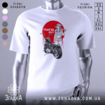 Футболка бунтарський настрій, біла, зображена на манекені, фон світло-сірий, принт з червоним колом, дівчина в окулярах з бейсбольною битою, мотоцикл поруч, текст 'YOU'RE NEXT' на принті.