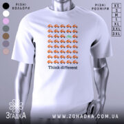 Футболка бути іншим. Біла футболка з принтом, на якому розташовані оранжеві автомобілі в ряд, а один зелений велосипед виділяється серед них. Фон нейтральний, а ракурс зосереджений на передній частині футболки.