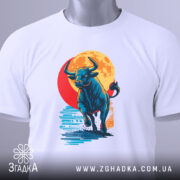 Футболка бик енергія, біла, складена на поверхні, фон світло-сірий, принт з биком, що біжить на фоні червоного сонця, з етикеткою на шнурку.