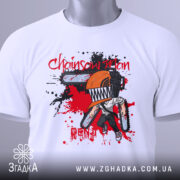 Футболка Chainsaw Man білого кольору, складена на поверхні, зображена з верхнього ракурсу, фон світлий, принт з персонажем з бензопилою, оранжевий шолом, червоні та чорні плями навколо.