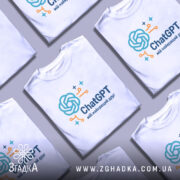 Футболка ChatGPT мій друг, біла, складена в групі з іншими футболками, фон світло-сірий, принт з логотипом ChatGPT у блакитному та оранжевому кольорах.