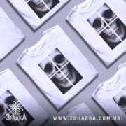 Футболка череп модний принт, біла, зображена на манекені, фон світло-сірий, принт зображає череп у чотирьох квадратах, деталі принта чіткі та контрастні.