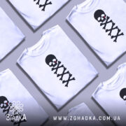 Футболка череп символ, біла, зображена з близького ракурсу на манекені, фон нейтральний, принт чорного черепа з червоною краплею та кістками.