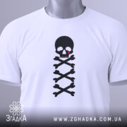 Футболка череп символ, біла, зображена зверху, складена на столі, фон світлий, принт чорного черепа з червоною краплею та кістками, з етикеткою.