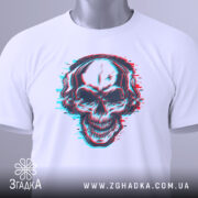 Футболка череп в навушниках, біла, складена на поверхні, фон світло-сірий, принт черепа з навушниками в стилі 3D, з етикеткою на зеленому шнурку.