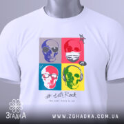 Футболка черепи рок стиль, біла, розкладена на поверхні, фон світло-сірий, принт з чотирьох черепів у кольорових квадратах, текст '# Let's Rock' під принтом, на комірці видна етикетка.