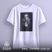 Футболка черниця тату білого кольору, підвішена на вішалці, фон світло-сірий, принт з чорно-білою фотографією дівчини в чернечому вбранні з татуюваннями на руках.