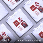 Футболка червоний акцент, біла футболка з принтом, зображена з правого ракурсу, фон нейтральний, принт містить червоні губи та зображення червоного автомобіля.