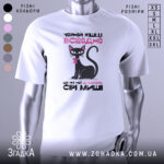 Футболка чорній кішці всеодно, біла, зображена з фронтального ракурсу на манекені, фон нейтральний, принт з чорним котом з рожевим бантиком та текстом.