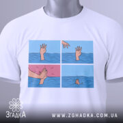 Футболка чорний гумор, біла футболка на столі, зображення принта з чотирма сценами, вид зверху, деталі рук, що з'являються з води, одна рука тягнеться до іншої, яка піднімається.