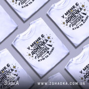Футболка чудова донечка, біла, зображена на манекені з правого боку, фон світло-сірий, принт чорного кольору з жовтими зірками та різними символами, текст українською мовою.