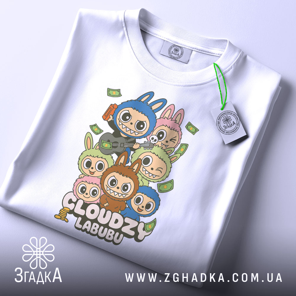 Футболка Cloudzy Labubu білого кольору, складена на поверхні, з видимим етикеткою, фон світло-сірий, принт з персонажами, які тримають гітару та інші предмети, оточені купюрами.