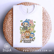 Футболка Cloudzy Labubu білого кольору, складена на плетеній кошику, фон білий, принт з персонажами, які тримають гітару та інші предмети, оточені купюрами.